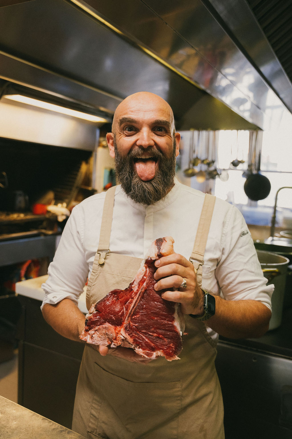 Un cuoco in cucina mostra un taglio di carne